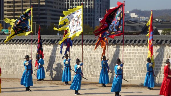 Guardias del palacio Gyeongbokgung en Seúl con hanbok y banderas durante la ceremonia tradicional de cambio de guardia