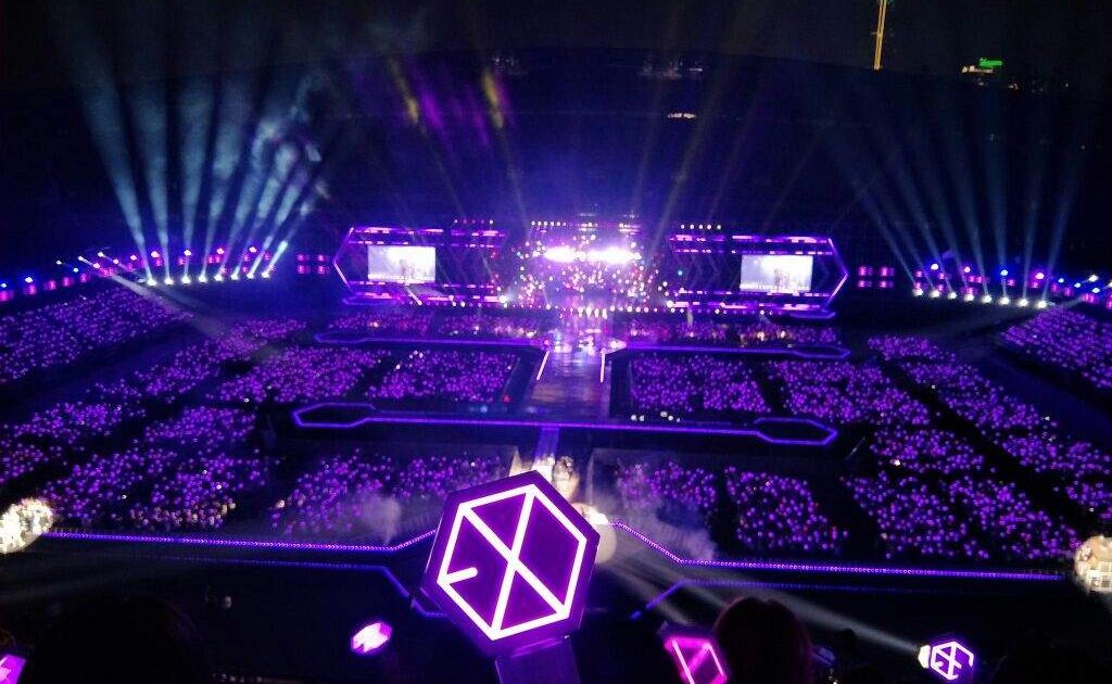 Mar de lightsticks iluminando un estadio durante un concierto de K-pop