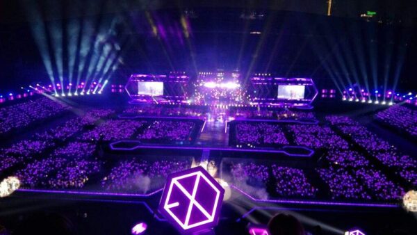 Mar de lightsticks iluminando un estadio durante un concierto de K-pop